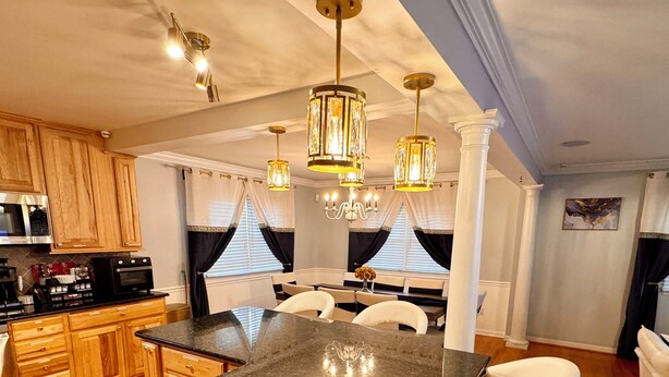 A kitchen with a central island, wooden cabinets, and a dining area with white chairs. - Mid-Term Luxury Family Stay/Hot Tub, 2 Fire Pits, Sauna, Massage Chair & Arcade (Alexandria)