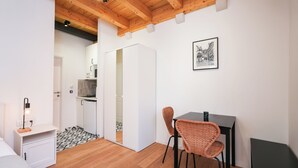 A room with a bed, a dining table with chairs, a kitchen area, and a framed picture on the wall. - South & Comfort (Dubrovnik)