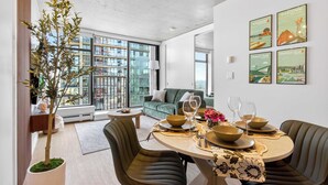 Un espace repas moderne avec une table ronde, des chaises et une plante en pot.