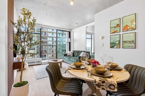 A modern dining area with a round table, chairs, and a potted plant.