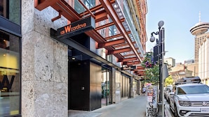 Une vue de rue avec un bâtiment portant l’inscription « Wcordova » et une voiture blanche garée sur le trottoir.