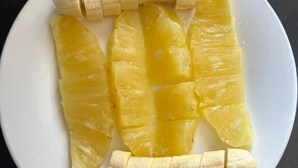 A white plate with sliced pineapple and banana pieces. - Vista Homes Villa (Kigali)