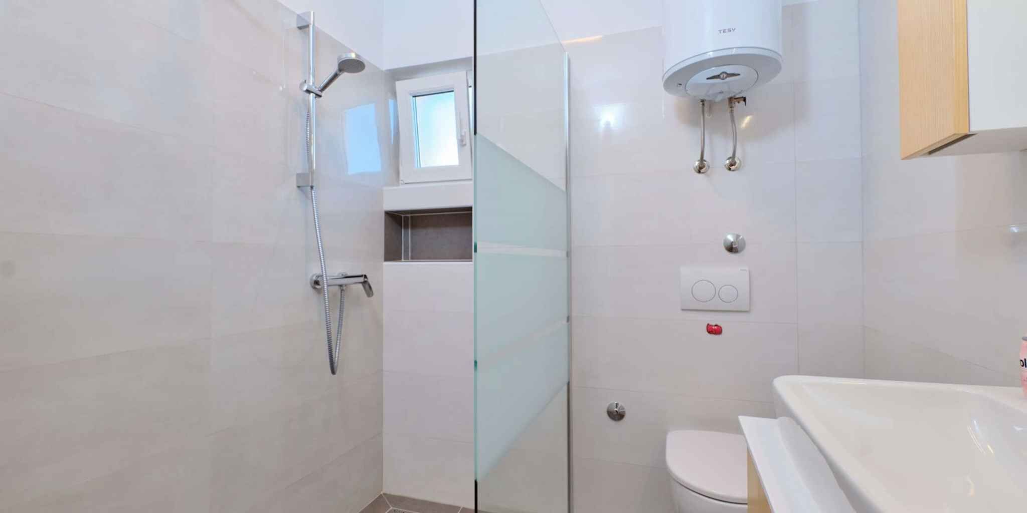 Une salle de bain moderne avec une douche à parois de verre, des toilettes et un lavabo.