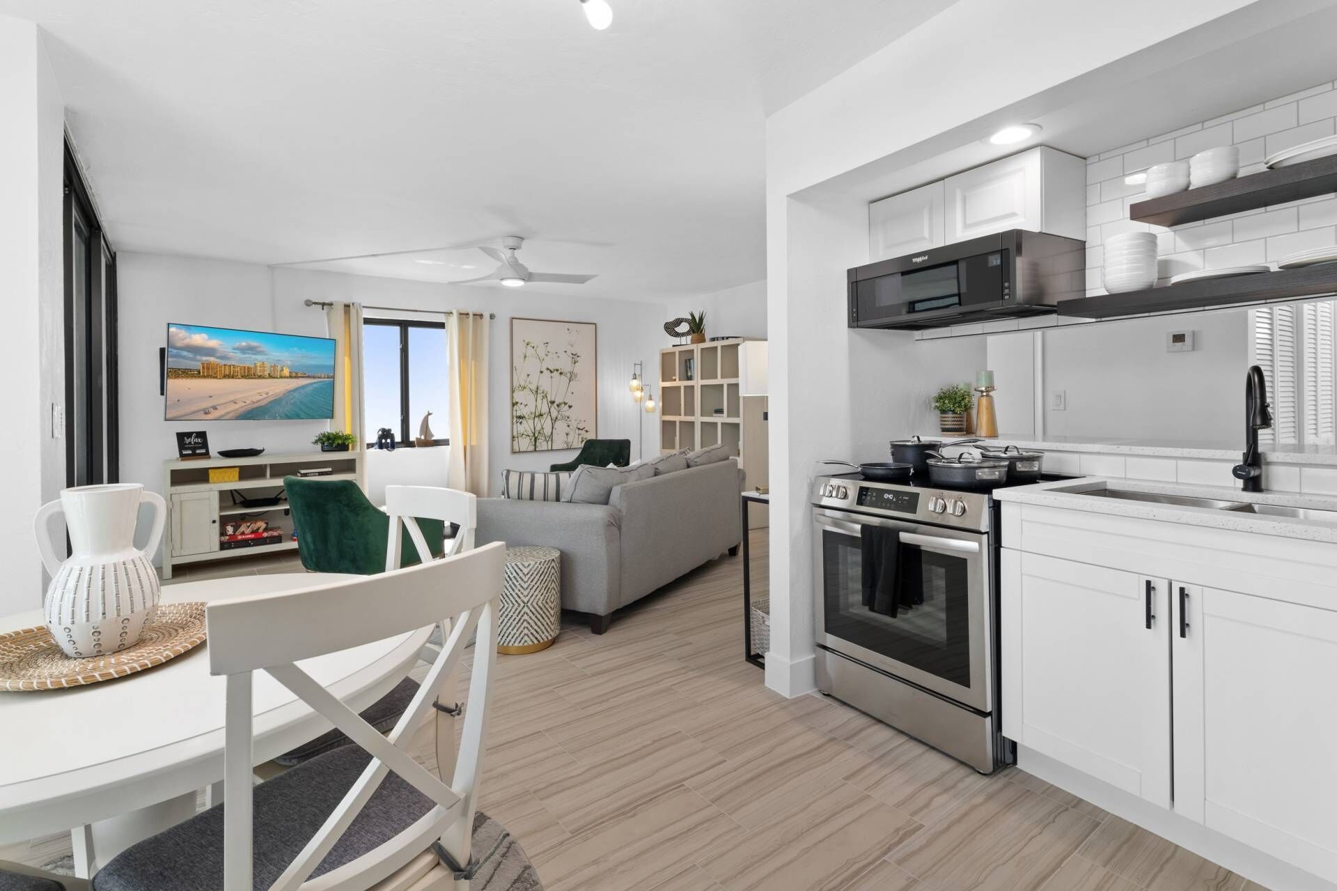 A modern kitchen with white cabinets, a built-in oven, and a microwave.
