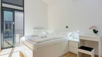 Una camera da letto moderna con un letto, comodini, una scrivania e una pianta in vaso.
