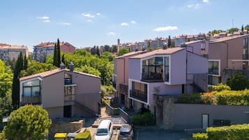 A residential area with modern apartment buildings, a parking lot, and a clear sky.