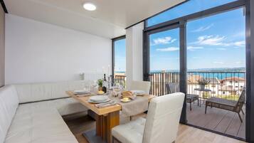 Un balcone moderno con un tavolo da pranzo apparecchiato per due persone, con vista panoramica.