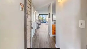 A hallway with a door labeled 'G05,' a light fixture, and a view into a room with a window.