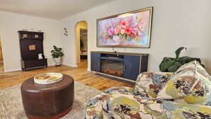 A living room with a fireplace, a sofa, a coffee table, and a painting on the wall.