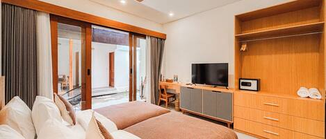 Une chambre d’hôtel avec deux lits, une télévision, un bureau et une armoire.