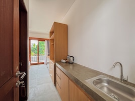 A modern kitchen with a stainless steel sink, wooden cabinets, and a view of the outdoors.