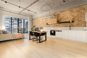 Apartamento moderno com área de jantar, cozinha e uma grande janela com vista para a cidade.