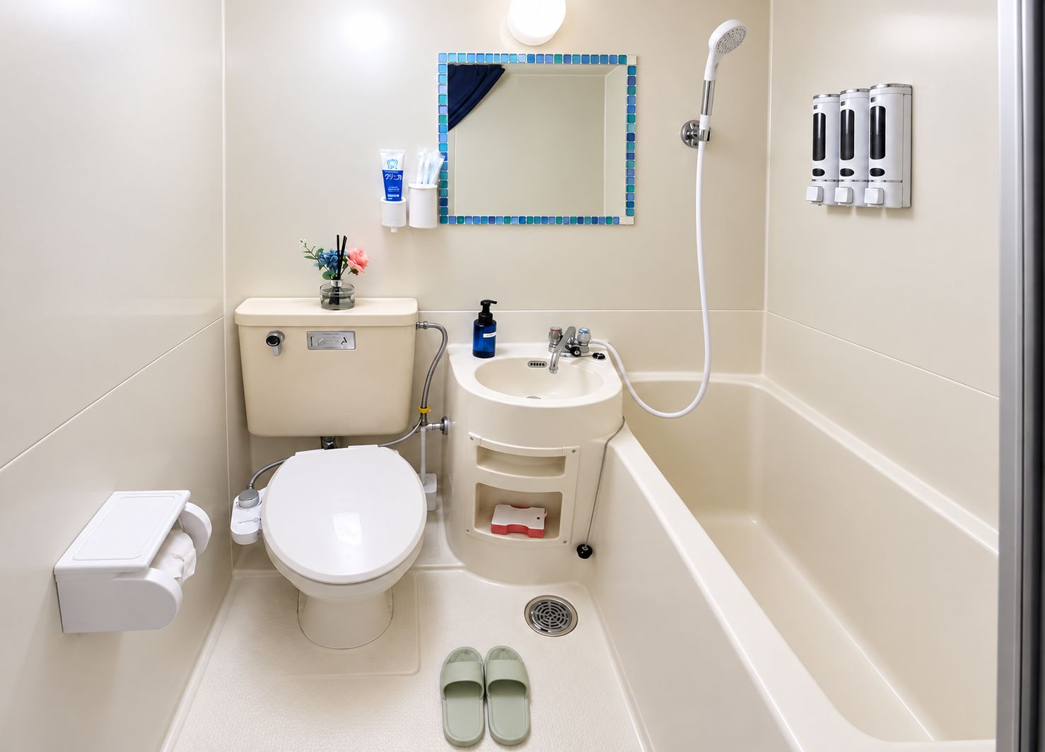 A bathroom with a toilet, sink, shower, and a mirror.