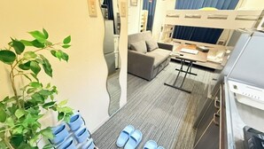 A compact room with a bunk bed, a sofa, a small table, and a plant. - GrAce Room IKEBUKURO (Tokyo)