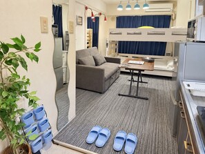A compact room with a bunk bed, a sofa, a small table, and a plant. - GrAce Room IKEBUKURO (Tokyo)