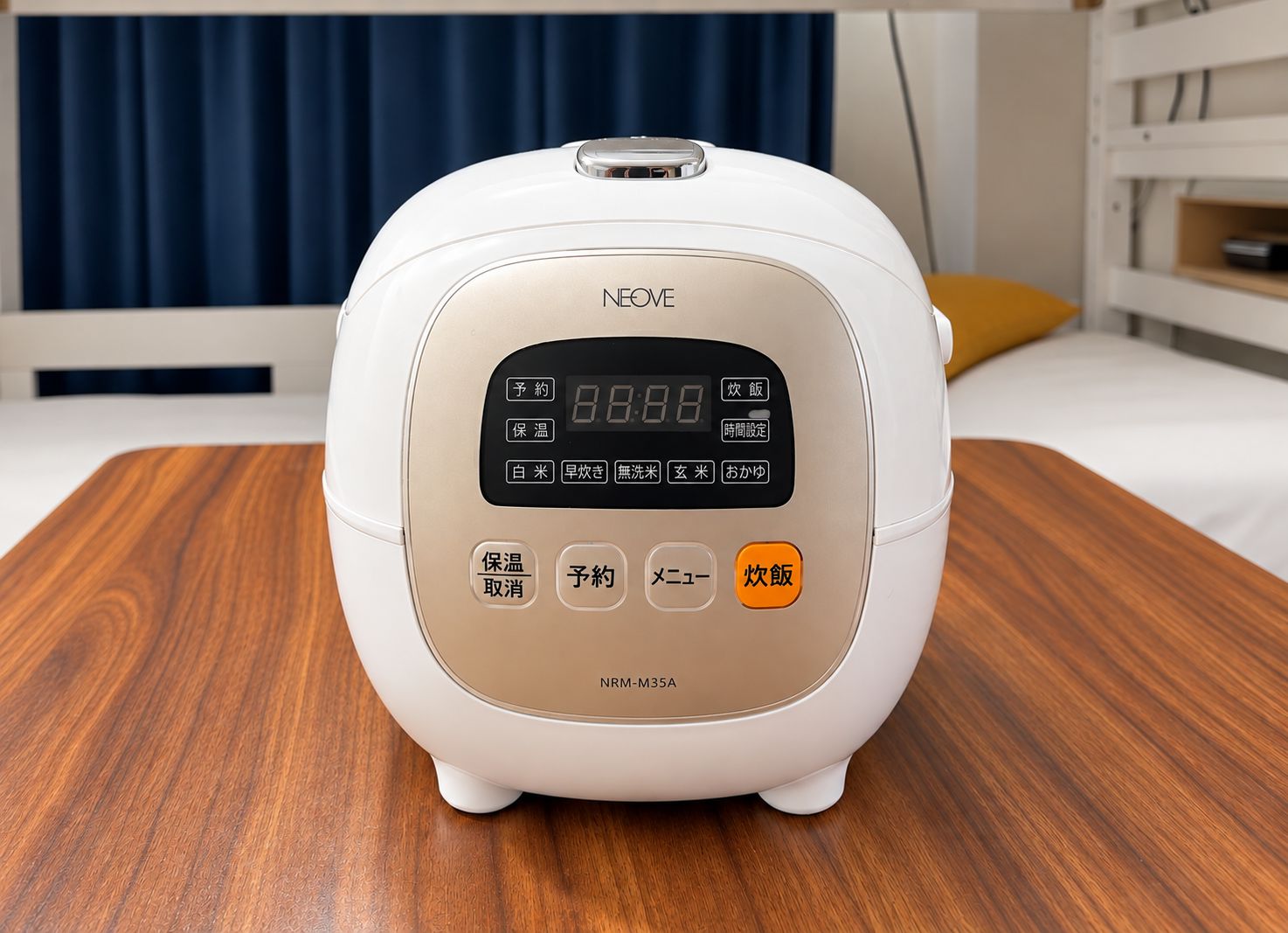 A white rice cooker with a digital display and multiple buttons, placed on a wooden surface.