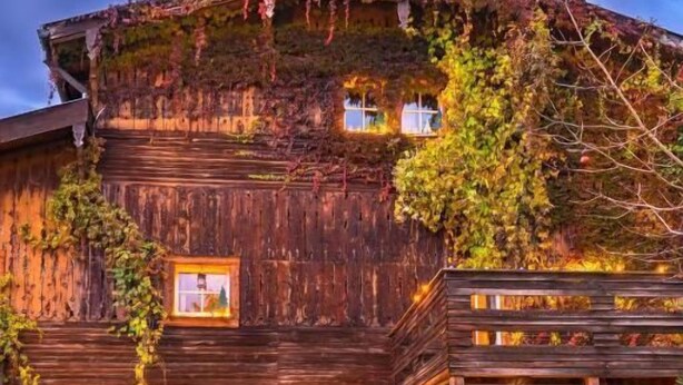 Ein hölzernes Gebäude mit Balkon und kleinem Garten.
