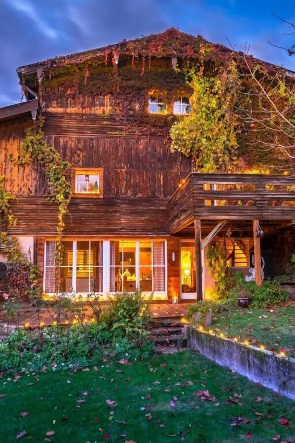A wooden building with a balcony and a small garden area.