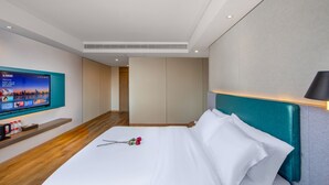 A modern hotel room with a large bed, a television mounted on the wall, and a wooden floor. - ZMAX HOTELS Fenghuang Ancient Town (Xiangxi)