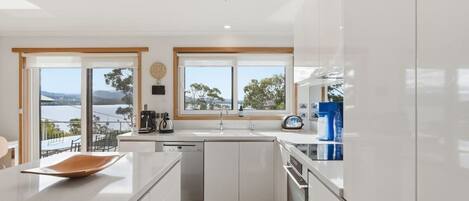 Una cocina moderna con una isla grande, vistas al exterior y piso de madera.