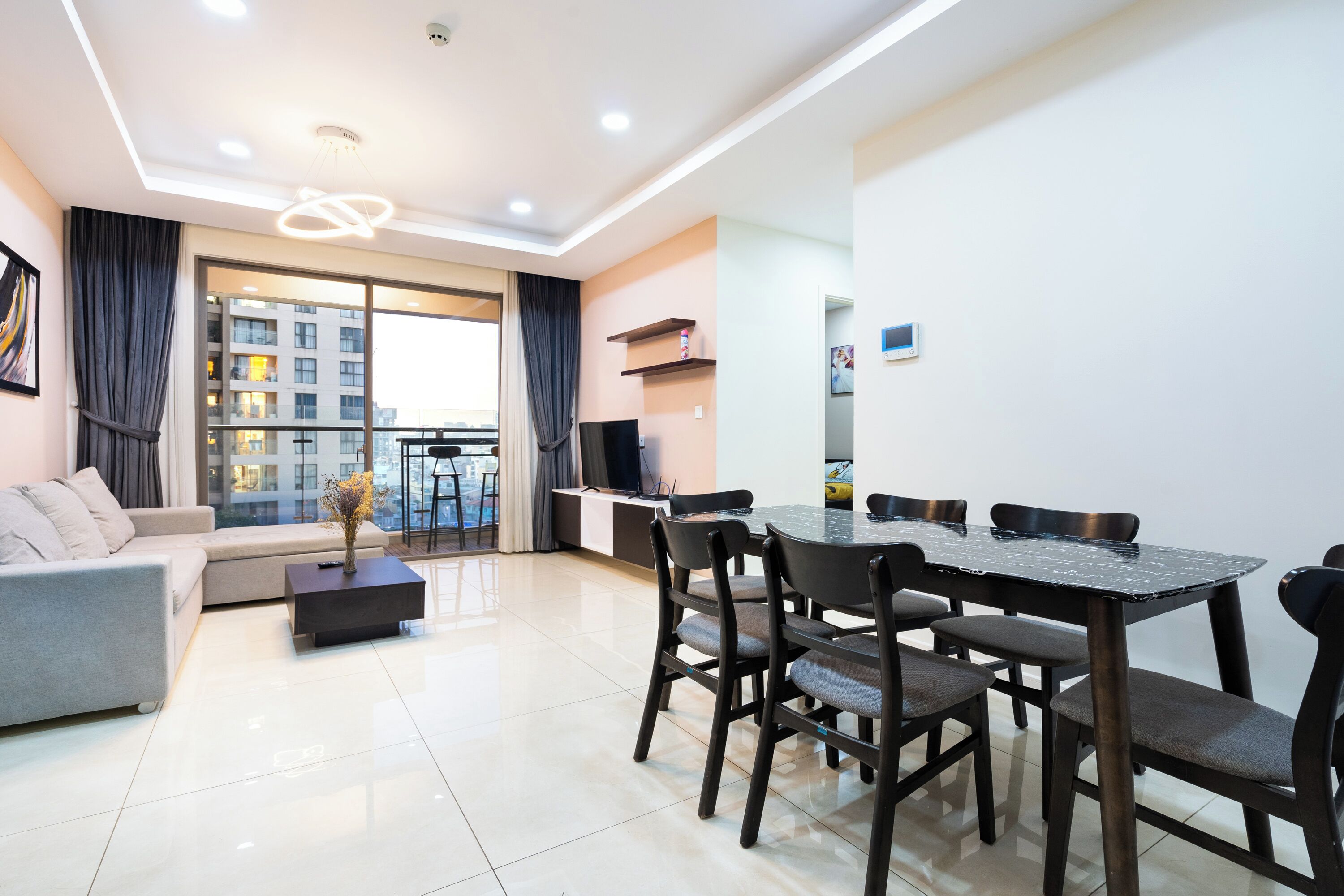 Uma sala de estar moderna com sofá, mesa de centro, mesa de jantar e cadeiras.