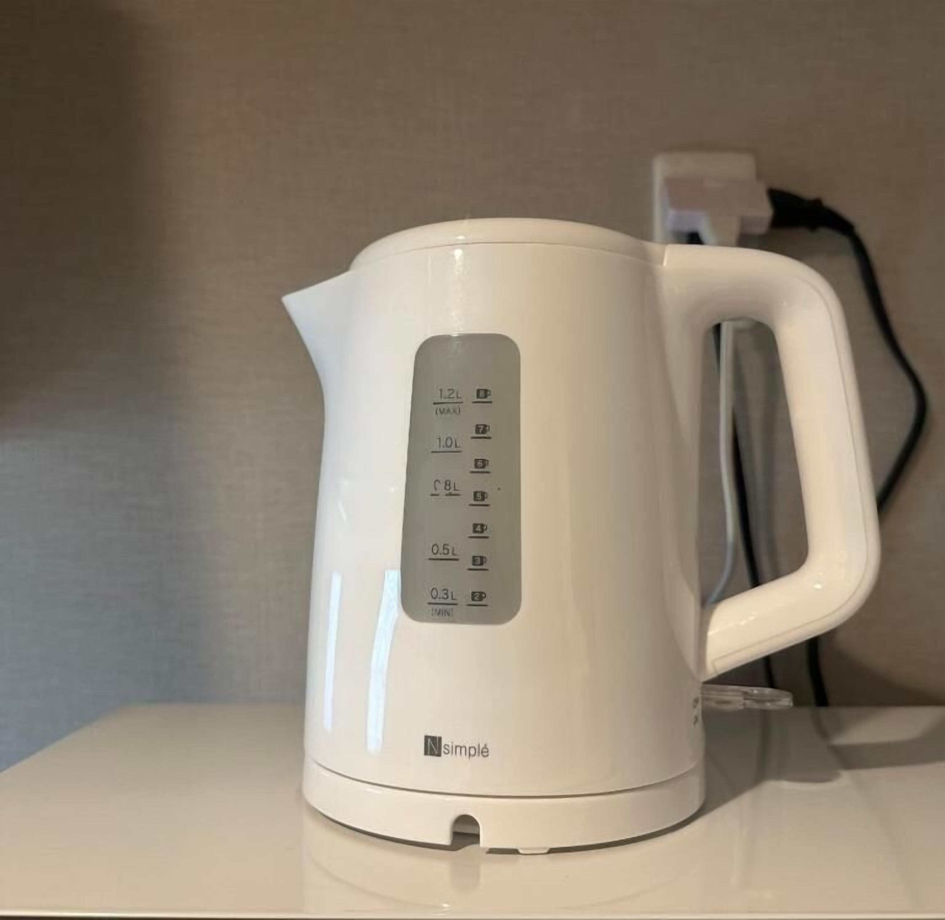 A white electric kettle with measurement markings and a brand logo.