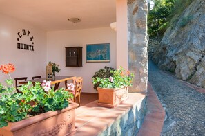 A patio with a table and chairs, potted plants, a wall-mounted cabinet, and a framed picture. - Holiday Residence La Cota Quinta, Rio Nell"elba (Rio)