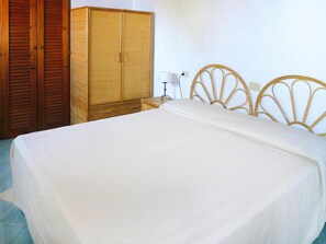 A bedroom with a bed, wooden wardrobe, and a bedside table with a lamp. - Holiday Residence La Cota Quinta, Rio Nell"elba (Rio)