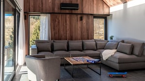 A modern living room with a sectional sofa, a small table, and a skateboard.