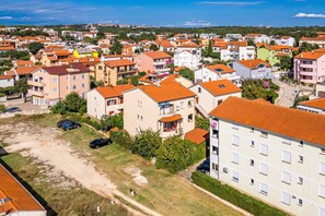 A residential area with multiple apartment buildings, some with balconies, and a clear view of the surrounding landscape. - Apartment Near Pula With Sea View Balcony (Medulin)