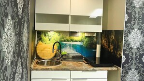 Una cocina con un lavamanos, una tabla de cortar de madera y un dispensador de toallas de papel.