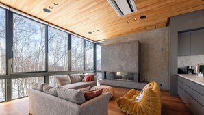 A modern living room with a sofa, a bean bag, and a fireplace. - Yuzen (Kutchan)