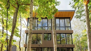 A modern multi-story building with large windows, surrounded by trees. - Yuzen (Kutchan)