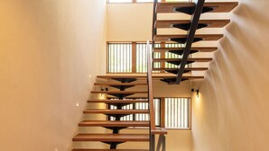 A modern interior with a wooden staircase, large windows, and a minimalist design. - Yuzen (Kutchan)