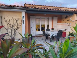 Un patio con mesa y sillas, una puerta y un muro con azulejos.