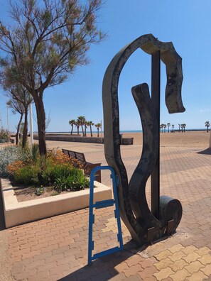 A sculpture in a public space with a paved walkway, benches, and palm trees. - Air-conditioned house near beach, terrace and private parking. Wifi fiber. Sleeps 4 (Valras-Plage)