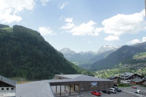 A building with a modern design, surrounded by a mountainous landscape. - Apartment for 5 People With Pool (Chatel)