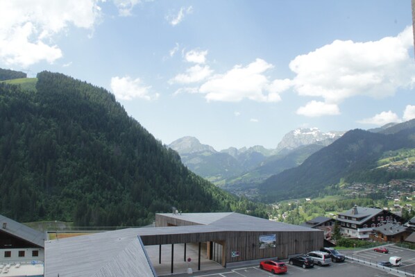 Un edificio de diseño moderno, rodeado de un paisaje montañoso.