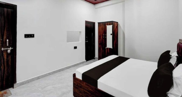 Een slaapkamer met een bed, een kledingkast en een deur.