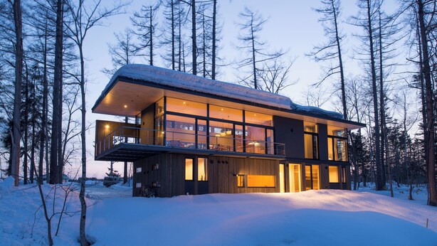 A modern two-story house with large windows, a balcony, and a snowy landscape. - Hiyoku (Niseko)
