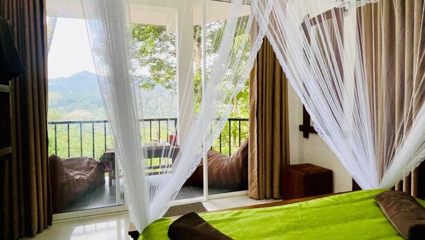 A bedroom with a bed, curtains, and a view of greenery. - Ella Hillcrest Heaven (Ella)