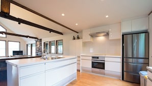 Una cocina moderna con una isla grande, electrodomésticos de acero inoxidable y una pared decorativa de piedra.