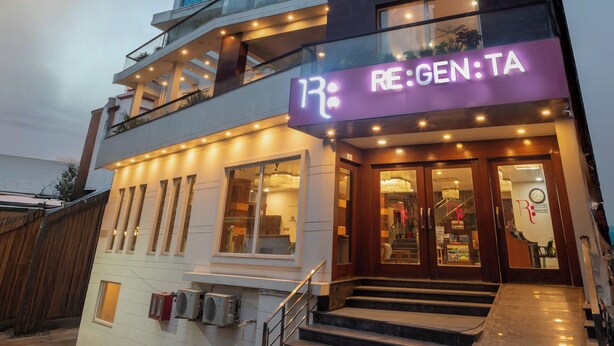 Moderni rakennus, jossa on kaksikerroksinen sisäänkäynti, selkeästi näkyvä portaikko ja kyltti, jossa lukee: ”RE:GEN:TA”.