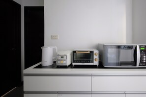 A kitchenette with a microwave, toaster, and coffee maker on a white countertop. - Taipei Main Station Modern Urban Stay 2B1b 5people (Taipei City)