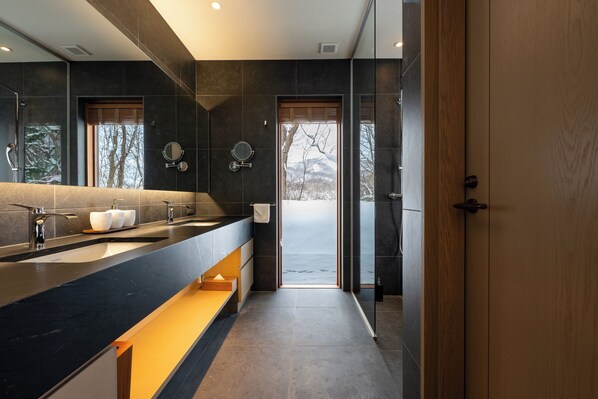 A modern bathroom with a large mirror, two sinks, and a wooden door leading to a view. - Kogetsu-To (Toyako)