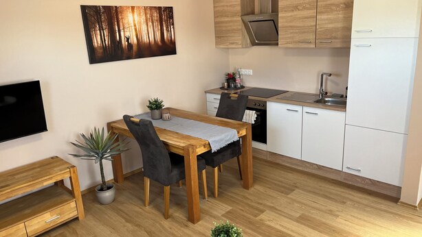 A modern kitchen with wooden cabinets, a built-in oven, and a white refrigerator.