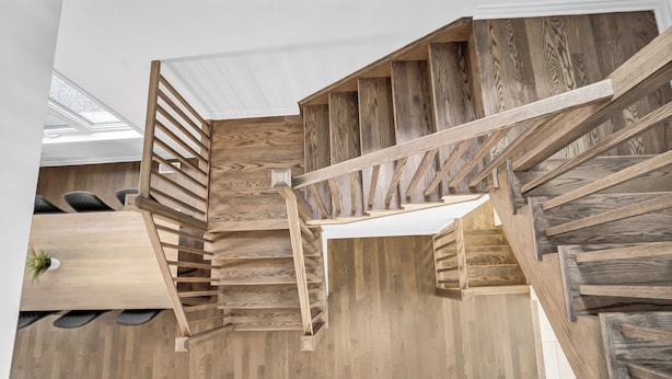 Un escalier en bois à plusieurs niveaux, surmonté d’une lucarne.