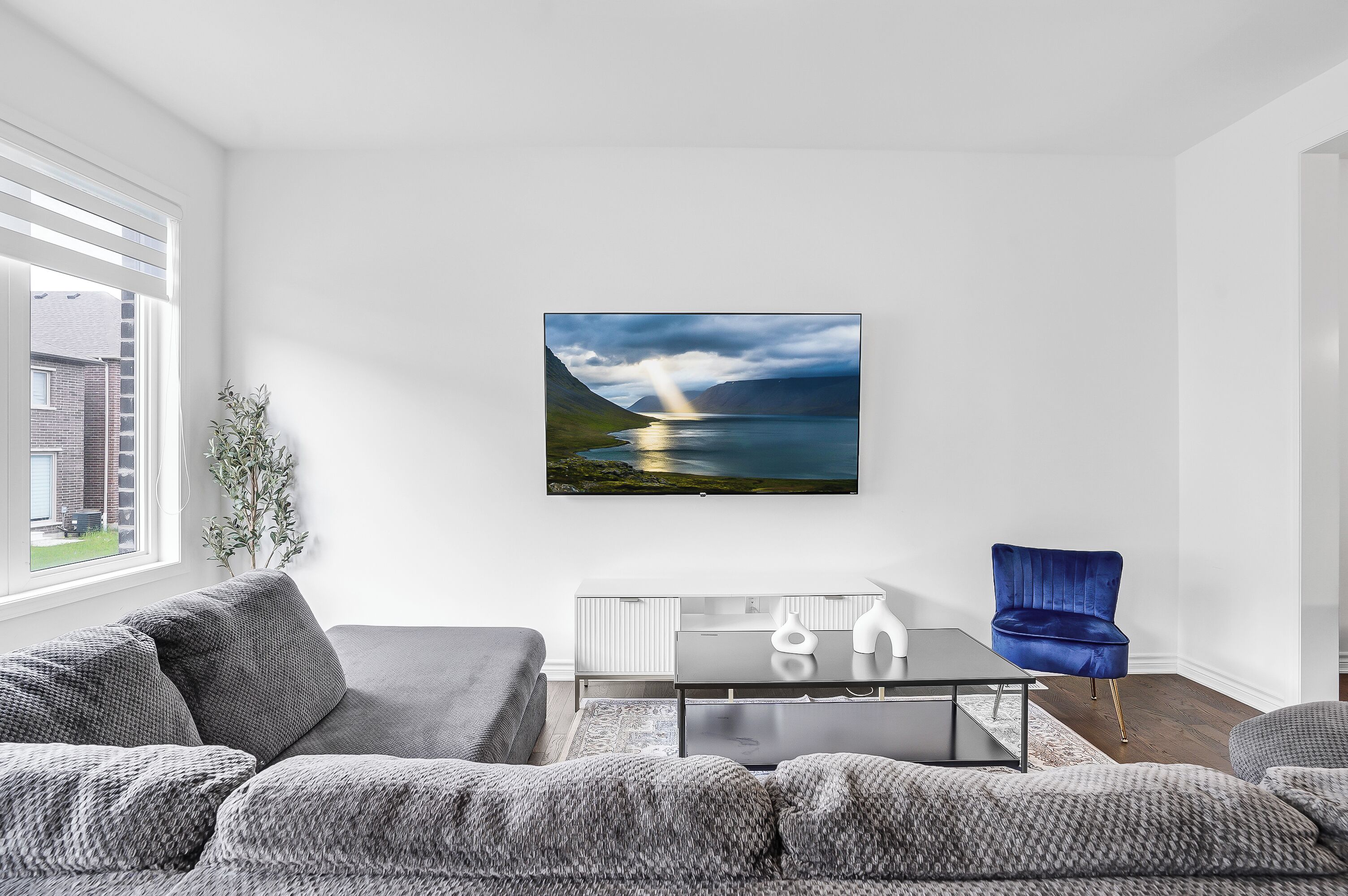 Una sala de estar moderna con un sofá, una mesa de centro y un sillón azul.