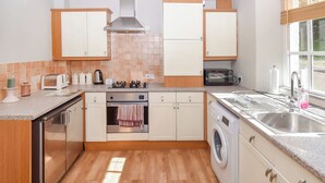 A modern kitchen with a dishwasher, oven, microwave, and sink. - 1 bedroom accommodation in Bowness-on-Windermere (Bowness-on-Windermere)