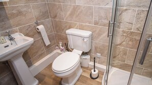 A bathroom with a toilet, sink, and shower. - 1 bedroom accommodation in Bowness-on-Windermere (Bowness-on-Windermere)